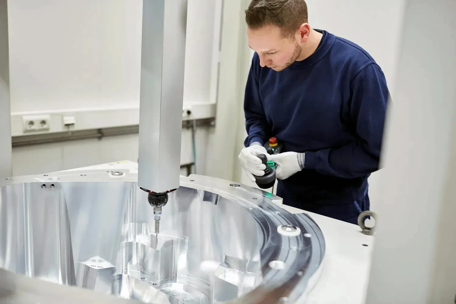 A Lemmens technician measuring a precision metal component.